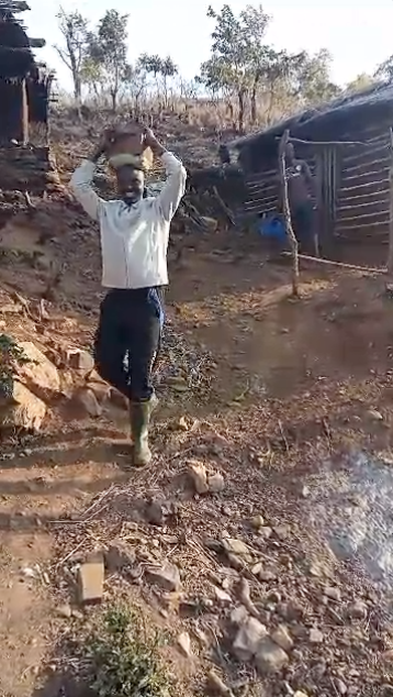 Man carries stone for a building project in a Tanzanian village